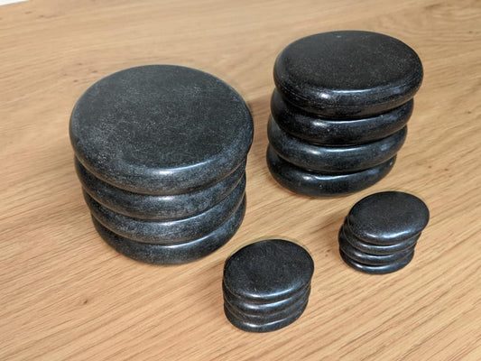 Stacks of black stones on a wooden surface