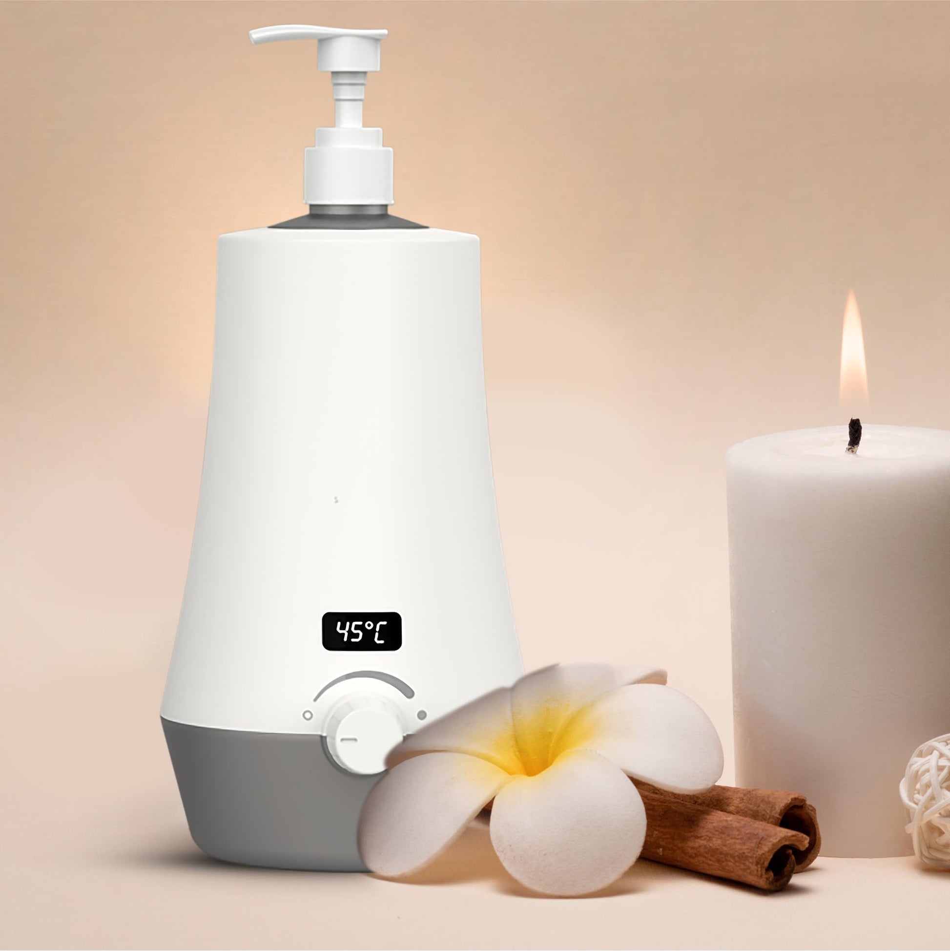 White and gray humidifier with digital display, plumeria flower, cinnamon stick, and candle on a beige background