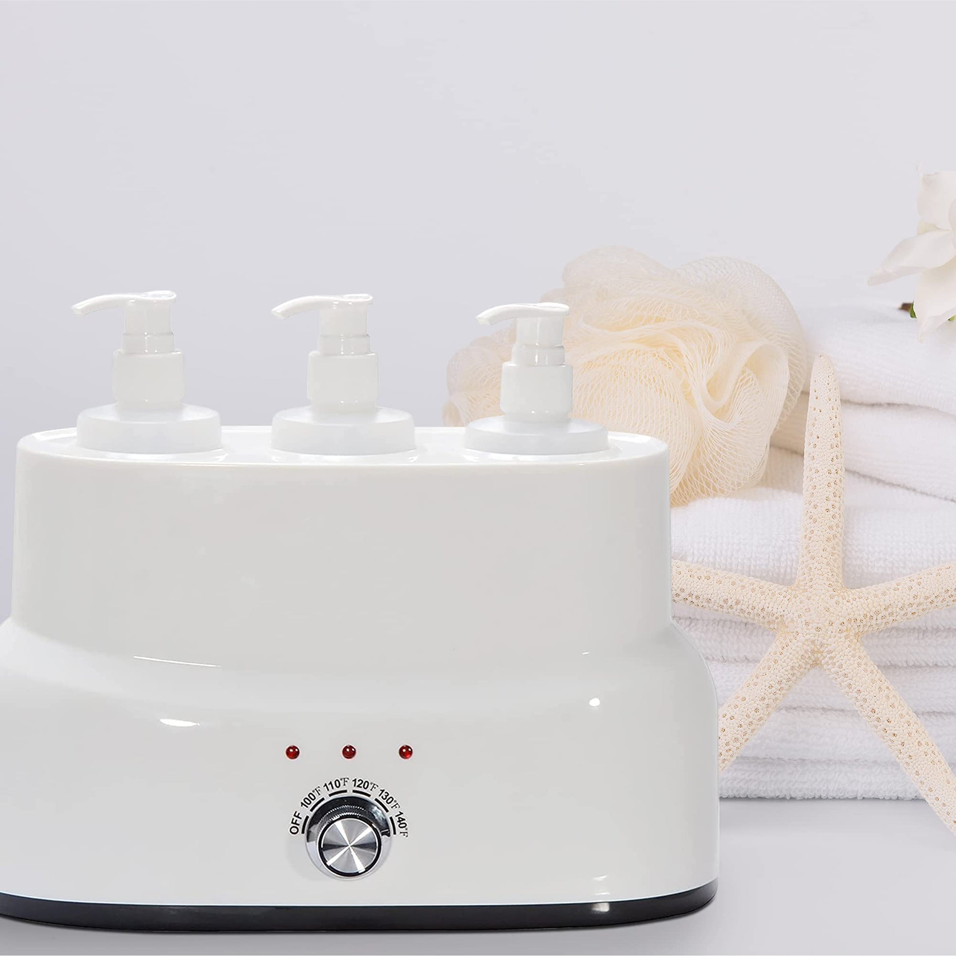White electric warmer with three pump bottles on a light gray background